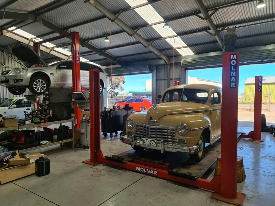 Classic vehicle and everyday car being worked on inside Revs Mechanical workshop